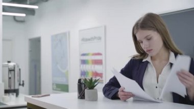 Yeni start-up ve gelecek için planlama stratejilerinin tanıtımı raporları ile çizelgeleri ile bir iş görünümlü kağıt takım elbise bir sekreter veya iş kadını Portresi. Işyeri. Ofis alanı.