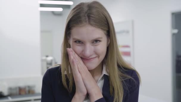 Portrait of a contented, happy, satisfied secretary or businesswoman in a business tight suit looking at the camera and showing her positive emotions. Workplace. Office space. — Stock Video