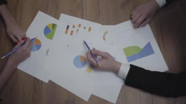 Büyüme oranlarını ve eğilimleri analiz eden tanınmayan iş adamlarıyla grafik veri şablonları tablosunun yukarıda görüntülenmesi. Işyeri. Ofis alanı.