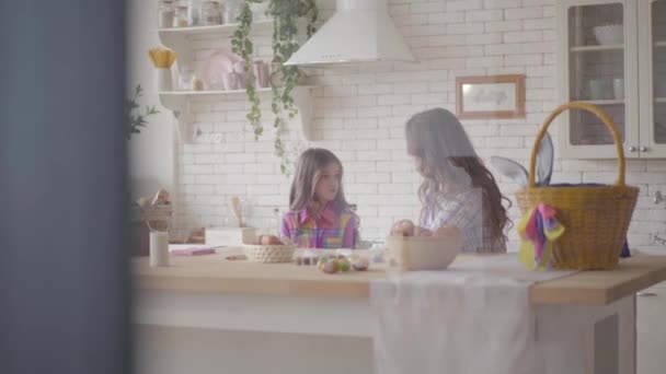 Молода мама і її дочка-підліток сперечаються на кухні. Жінка пояснює дівчині причини, але вперта дочка захищає її думку. Відносини матерів і дочок. Щаслива сім'я . — стокове відео