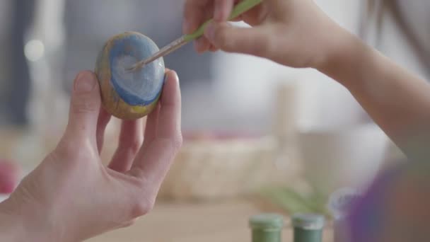 Primer plano de las manos madre e hija colorear huevos de Pascua con colores y cepillo. Huevos coloridos de Pascua. Preparación de la Pascua. Madre e hija se divierten juntas . — Vídeo de stock