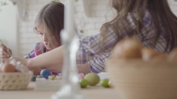 Mujer y niña para colorear huevos de Pascua con colores y cepillo. Preparación para las vacaciones de Pascua. Una familia feliz . — Vídeo de stock