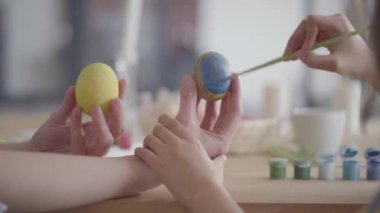 Tanınmayan küçük kız paskalya yumurtası üzerinde küçük bir fırça yakın kullanarak bir kalp boyama. Paskalya tatili için hazırlık. Yaratıcılık kavramı