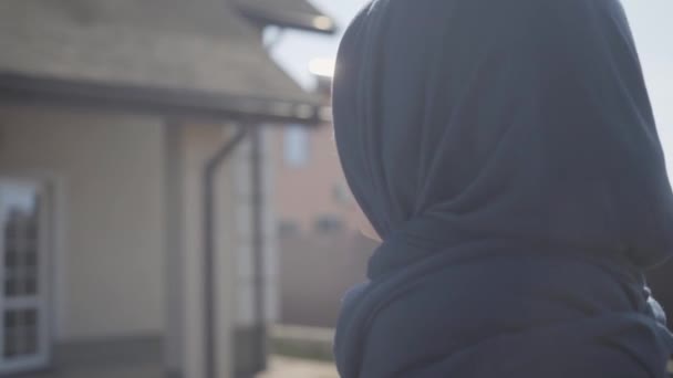Προφίλ πορτρέτο της όμορφης νεαρής μουσουλμανικής γυναίκας απολαμβάνοντας την άνοιξη καιρός στο δρόμο φορώντας παραδοσιακή μαντίλα. Κοντινό — Αρχείο Βίντεο