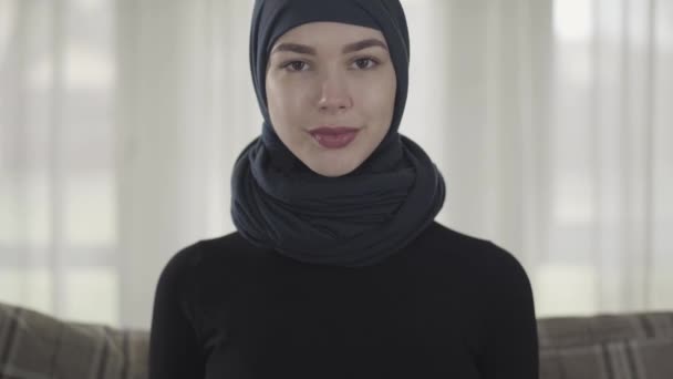 De cerca retrato exitoso confiado joven musulmana mujer de negocios mirando a la cámara sonriendo feliz usando pañuelo tradicional en el fondo de la oficina . — Vídeos de Stock