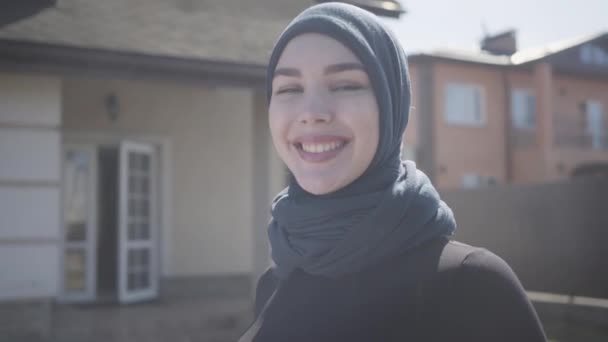 屋外で伝統的なヘッドスカーフを着て幸せな笑顔のカメラを見て成功した自信のある若いイスラム教徒のビジネスウーマンの肖像画. — ストック動画