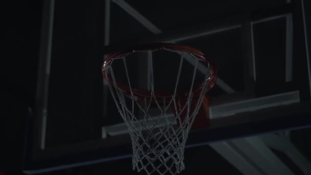 Basketbal net close-up. Een man, speler zet een bal binnen basketbal hoepel. — Stockvideo