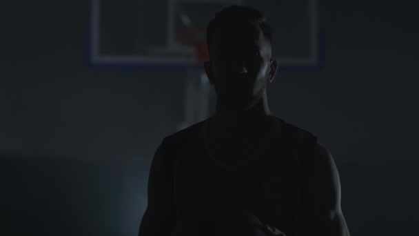 Portret van knappe zelfverzekerde ongeschoren man, basketbalspeler, die bal in gespierde handen vasthouden — Stockvideo