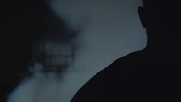 バスケットボール選手の背中とバスケットボールネットの周りに煙の雲 — ストック動画