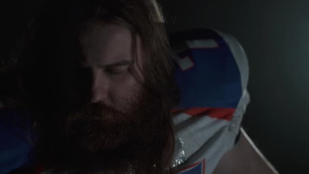 Close-up portret van een bebaarde American Football speler met lang haar en baard in sportuitrusting schreeuwen op zoek in de camera. — Stockvideo