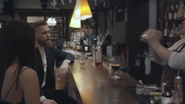 Ervaren zelfverzekerde ober staande achter de bar van een duur restaurant of pub maakt een cocktail met een shaker. — Stockvideo