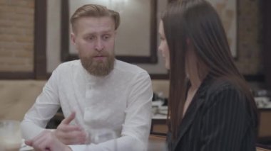 Glamour esmer kadın ve yakışıklı sakallı sarışın adam masada oturuyor. Adam kız arkadaşına bir hikaye anlatıyor. Sevimli çiftin bir randevusu var. Kamera sola ve sağa hareket ediyor