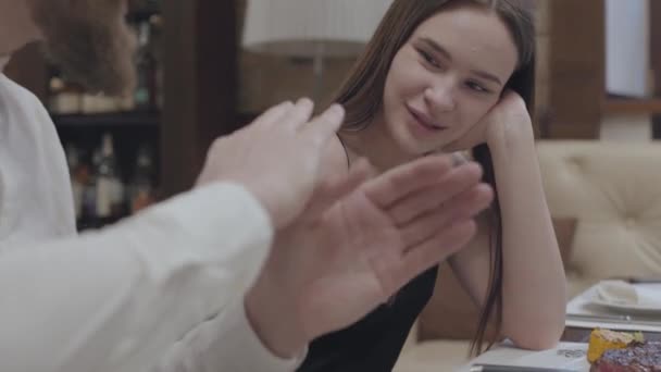 Pareja joven cenando o cenando en un restaurante. Un hombre cuenta la historia de su amado. La pareja pasa tiempo juntos. La relación de una pareja joven . — Vídeos de Stock