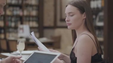 Güzel esmer kadın ve sarışın sakallı adam kafede yakın masada çalışıyor. Bayan kağıtları okuyor, elinde tablet tutan adam. İş arkadaşıile toplantı