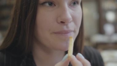 Yakın portre genç güzel kadın pahalı restoranda oturan ve coca cola ile tavuk nuggets yeme.