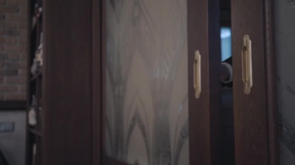 재킷을 입은 알아볼 수 없는 남자가 미닫이문에 들어가 고 그 뒤에 문을 닫고 식당에서 가까이. 아름다운 인테리어 디테일 — 비디오