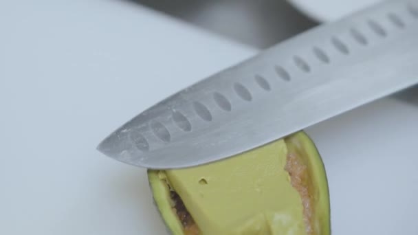 Chef preparando aguacate relleno poniendo salsa amarilla, mostaza en él de cerca con un cuchillo grande. El cocinero prepara comida en la cocina del restaurante. Preparación de mariscos — Vídeos de Stock