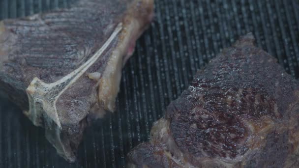 Acercamiento de dos piezas de carne cruda cocinando en la cocina del restaurante. El chef preparando sabrosa comida . — Vídeos de Stock