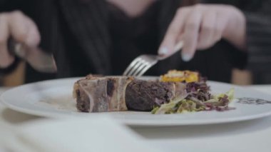 Tanınmayan adam pahalı bir restoran veya kafe yakın lezzetli bir et yemek yiyor.