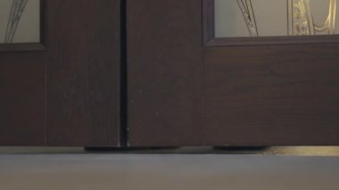 Siyah ayakkabılı yakın çekim erkek bacakları, kapıları açaktan bir restorana veya kafeye girer.