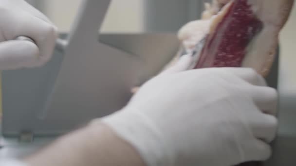 Cierre la mano del chef sosteniendo la carne congelada cubierta con cubierta amarilla acostada sobre la mesa. El cocinero prepara comida en la cocina del restaurante. Preparación de plato de carne — Vídeo de stock