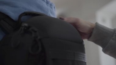 Arka da siyah rahat bir sırt çantası yakın. Arkada kadın el sabitleme çantası