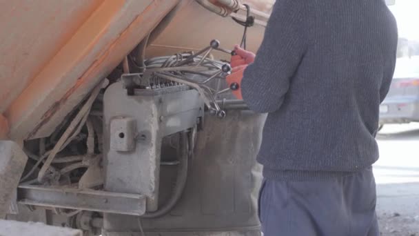 De werknemer in Casual kleding zet op Dumpster met trash machine. Achteraanzicht van de man die het vuilnismachine werk regelt. — Stockvideo