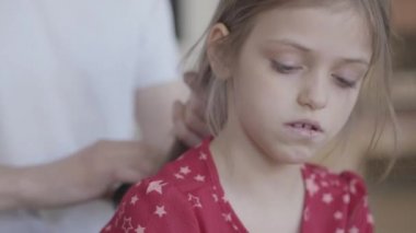 Portre genç sakallı baba küçük kızının saçlarını tararken çocuk aynanın önünde kabarık halıda yerde oturan oyuncaklarını tarıyor. Aile eğlencesi. Babalık, sevecenlik