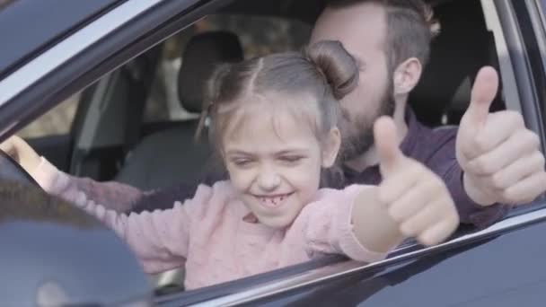 Retrato de pai hipster e filha bonita sentada no assento dos motoristas e feliz com sorrisos polegares para cima — Vídeo de Stock