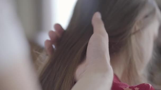 Hands of the father slowly brushing the long hair of his little girl close up. Family leisure. Fatherhood, caring, parenthood, love. Back view — Stock Video