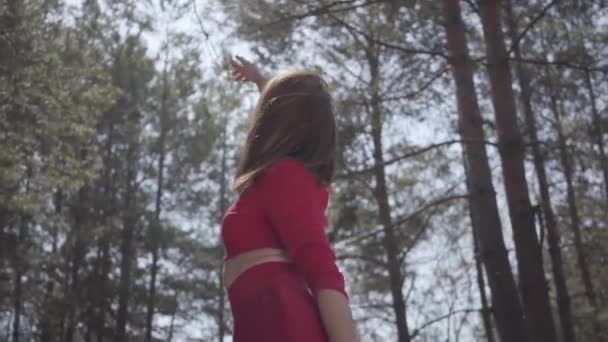 Portrait portrait graceful womans body in red dress in the forest. Lady raises hand in the sky — Stock Video