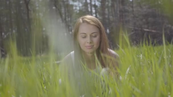 Hermosa mujer en la hierba verde alrededor de un bosque espectacular — Vídeos de Stock