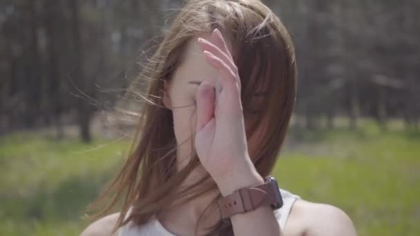 Portrait d'une belle jolie fille souriante avec des cheveux soufflant dans le vent. Superbe brune sportive tendre et gracieuse en plein air . — Video