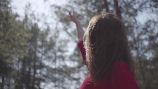 Graceful womans body in red dress in the forest. Lady raises hand in the sky. Slow motion. — Stock Video