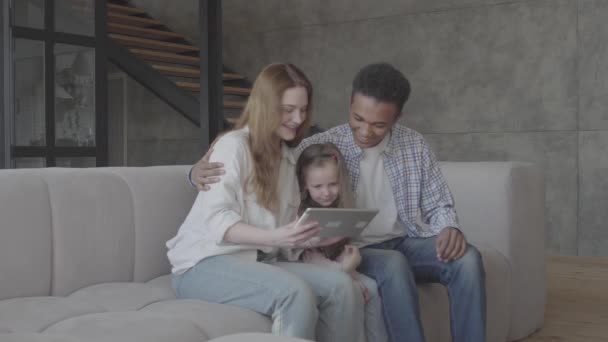 Young blond woman caucasian sit with african black man and between them is small adorable daughter. International family. Family relationships. — 비디오