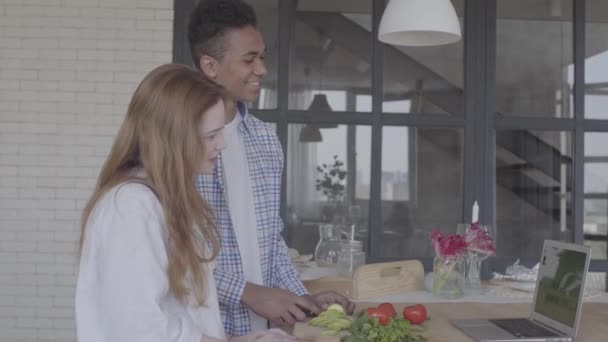 Portrait heureux couple interracial préparer le petit déjeuner ou le déjeuner dans une belle cuisine moderne. Le mari afro-américain et la femme blanche cuisinent ensemble. Relations familiales . — Video