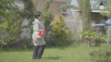 Yaşlı kadın arka bahçede içinde lalelerle sepetle yürüyor. Yetişkin torun gelir ve bayan, adam onun büyükanne ziyaret kucaklar. Aile toplantısı, dostane ilişkiler