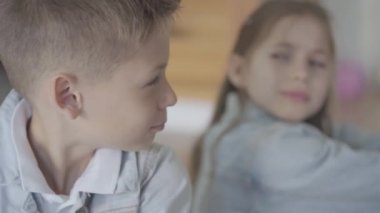 Portre küçük kafkas erkek ve kız kardeş ikizler rahatsız ve birbirlerine bir hoşnutsuz yüzleri ile sırtlarını kızgın oturup
