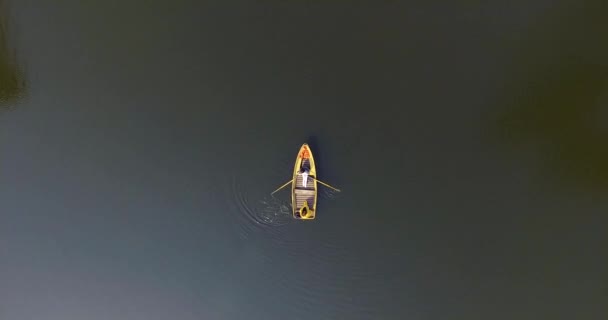 Två flickor i den lilla båten på en vacker reflekterande flod. Aktiv livsstil, samband med naturen. Drönarskytte, uppifrån, antenn skott. Kameran rör sig högre, zoomar — Stockvideo