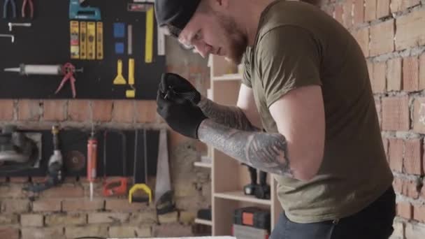 Professioneller Tischler in Mütze, der mit elektrischen Drähten arbeitet. zu viel Werkzeug für die Möbelherstellung. Konzept der Handfertigung. Handwerker arbeitet in einer Werkstatt. — Stockvideo