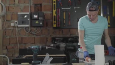 Şapkalı zanaatkar portresi onun çalışmalarında yer aldı. Marangozluk mesleği. El üretim kavramı, Craftman bir atölyede çalışıyor.
