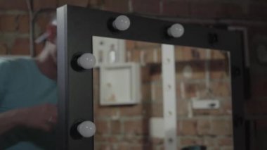 Aynada elektrikçi vidaampuller yakın. El üretim kavramı. Mobilya üretim fabrikası. Kendi işi. Craftman bir atölyede çalışıyor.