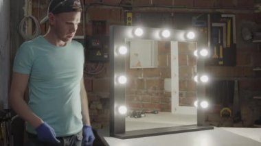 Marangoz müşteri için aynada ampuller yapma ve yüzeyi temizleme bitirdi. Işıklar açık. El üretim kavramı. Mobilya üretim fabrikası. Kendi işi. Craftman işleri