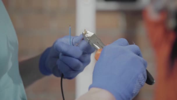 Mains dans les gants travaillant avec des fils électriques avec des outils. Fabrication manuelle. Artisanat travaille dans un atelier . — Video