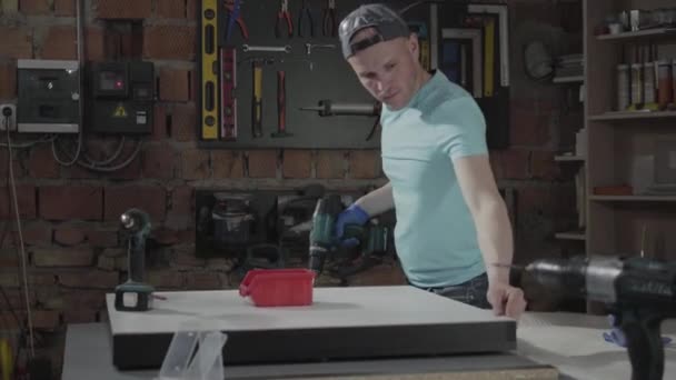 Portrait artisan ingénieur concentré sur le forage d'un trou avec outil sur le fond d'un petit atelier avec instruments — Video