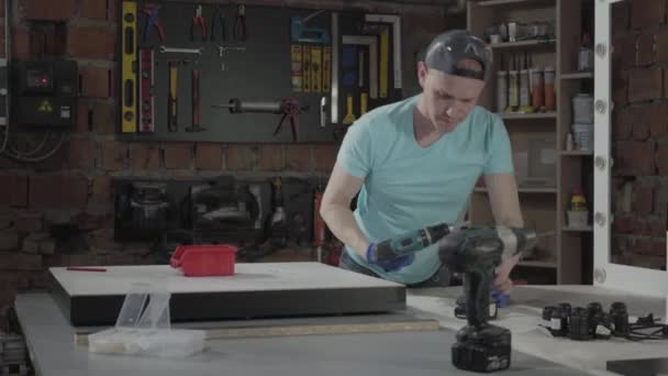 Portret umiejętności rzemieślniczy mistrz inżynier koncentruje się na wiercenia otworu z narzędziem na tle małego warsztatu z instrumentami — Wideo stockowe