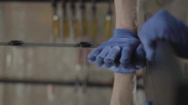 Marangozun eldivenli elini ayna yüzeyine bastırarak tahtaya yapıştırın. El üretim kavramı. Mobilya üretimi. Craftman bir atölyede çalışıyor.