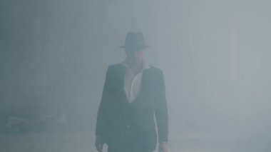 Fedora şapka ve klasik takım elbise acımasız gangster dumandan yürümek. Yavaş çekim. Terk edilmiş harap bina. Kendine güvenen işadamı rahatlatıcı.