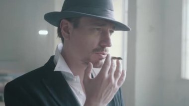 Terk edilmiş bir binada puro içen şapkalı portre kendine güvenen bir adam. Mafyanın patronu boş bir binada. Ceza dairesi portresi, yakın çekim. Yavaş çekim
