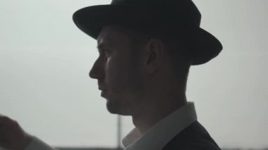 Yakın mesafeden genç adam fedora şapkasını çıkardı. Terk edilmiş harap bina. Kendine güvenen işadamı rahatlatıcı